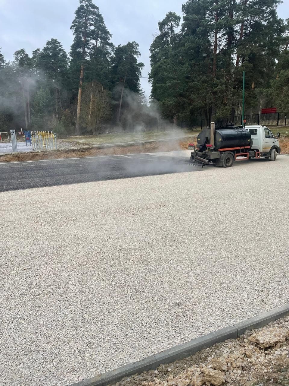 Асфальтирование парковки — каток уплотняет покрытие в Калуге